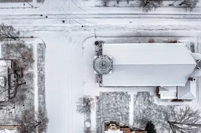 Drone shot of a snow-covered church and streets in Wabasha, MN during winter.